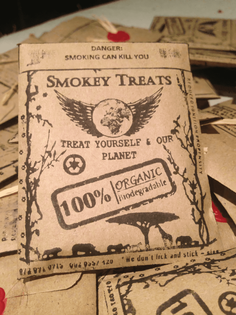 The Original "Smokey Treats" which are eco conscious hand rolled cigarettes, sold in a small envelope that had been hand stamped. They have biodegradable filters, unbleached cigarette paper and organic tobacco. It is an eco conscious cigarette product, but still bad for one's health. The idea is to present the eco conscious, sustainable, environmental, compostable, natural, and the eco aspects of the product. Die Original "Smokey Treats", umweltbewusste, handgerollte Zigaretten, verkauft in einem kleinen Umschlag, der von Hand gestempelt wurde. Sie haben biologisch abbaubare Filter, ungebleichtes Zigarettenpapier und organischen Tabak. Es handelt sich um ein umweltbewusstes Zigarettenprodukt, das jedoch immer noch schädlich für die Gesundheit ist. Die Idee ist, die umweltbewussten, nachhaltigen, umweltfreundlichen, kompostierbaren, natürlichen und ökologischen Aspekte des Produkts zu präsentieren.